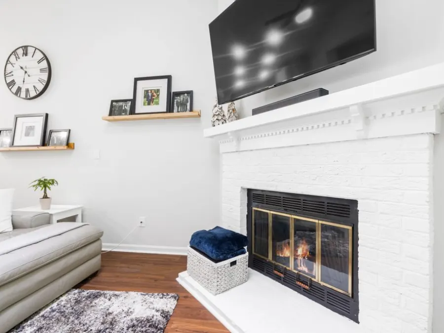 A bright living room with white walls and a white-painted fireplace — illustrative stock photo